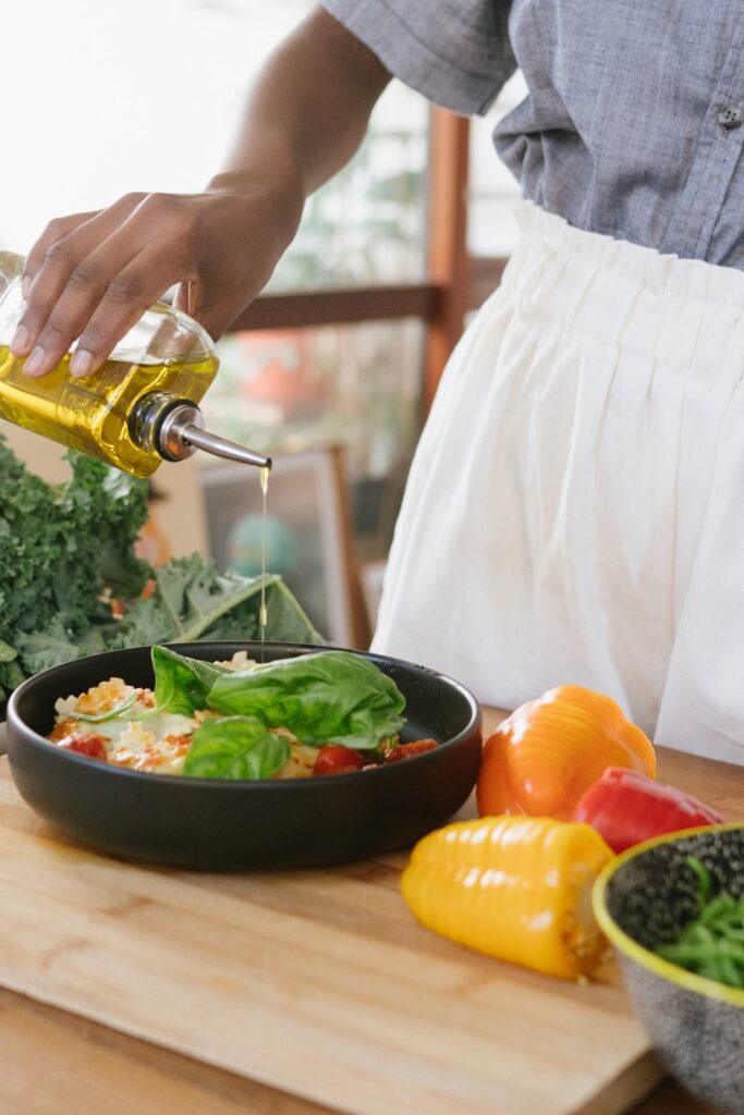 Cucina mediterranea - donna che usa olio d'oliva
